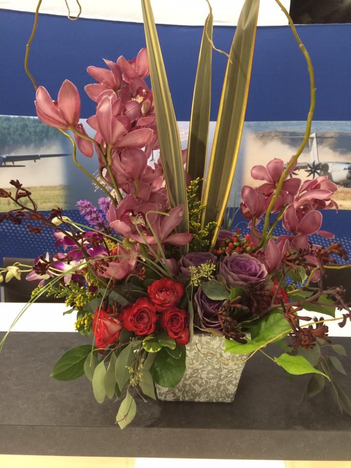 a vase filled with pink flowers and red roses