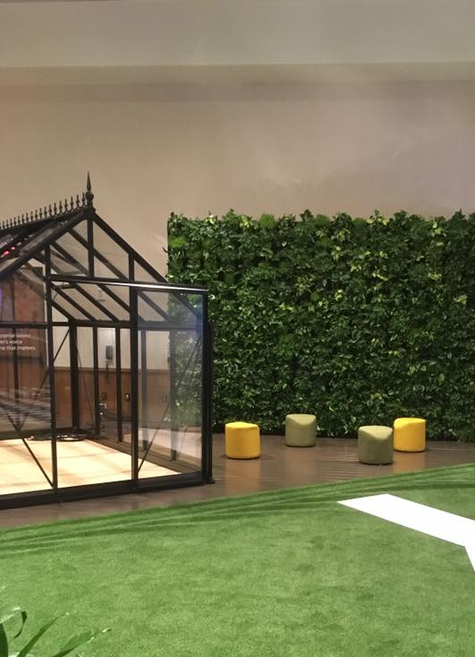 a greenhouse with a green wall behind it