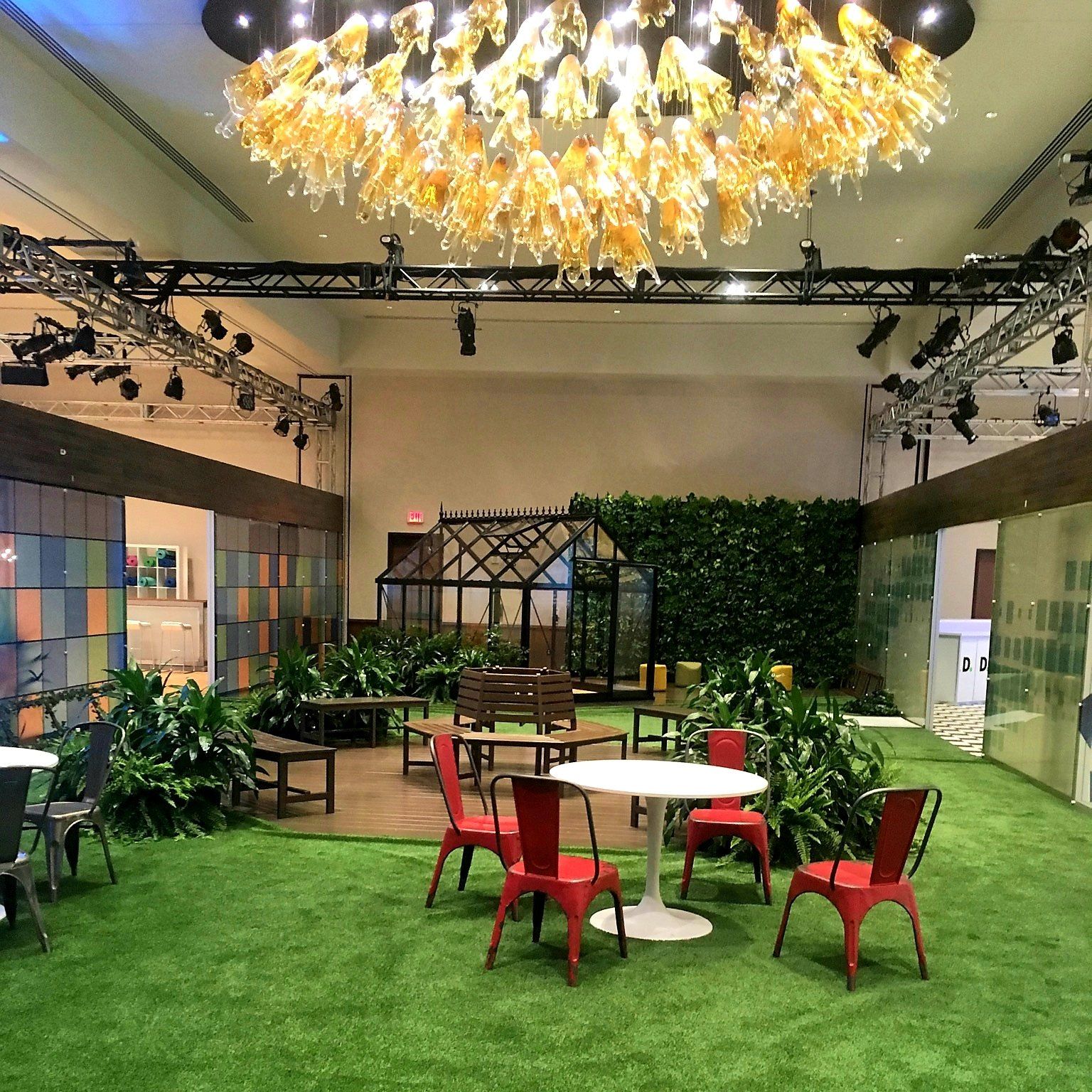 a large room with tables and chairs under a chandelier