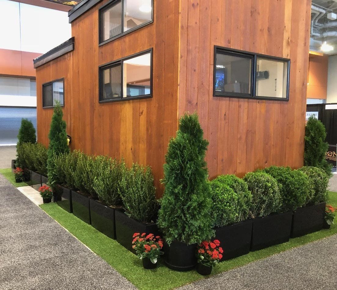 a small wooden house with a lot of plants in front of it