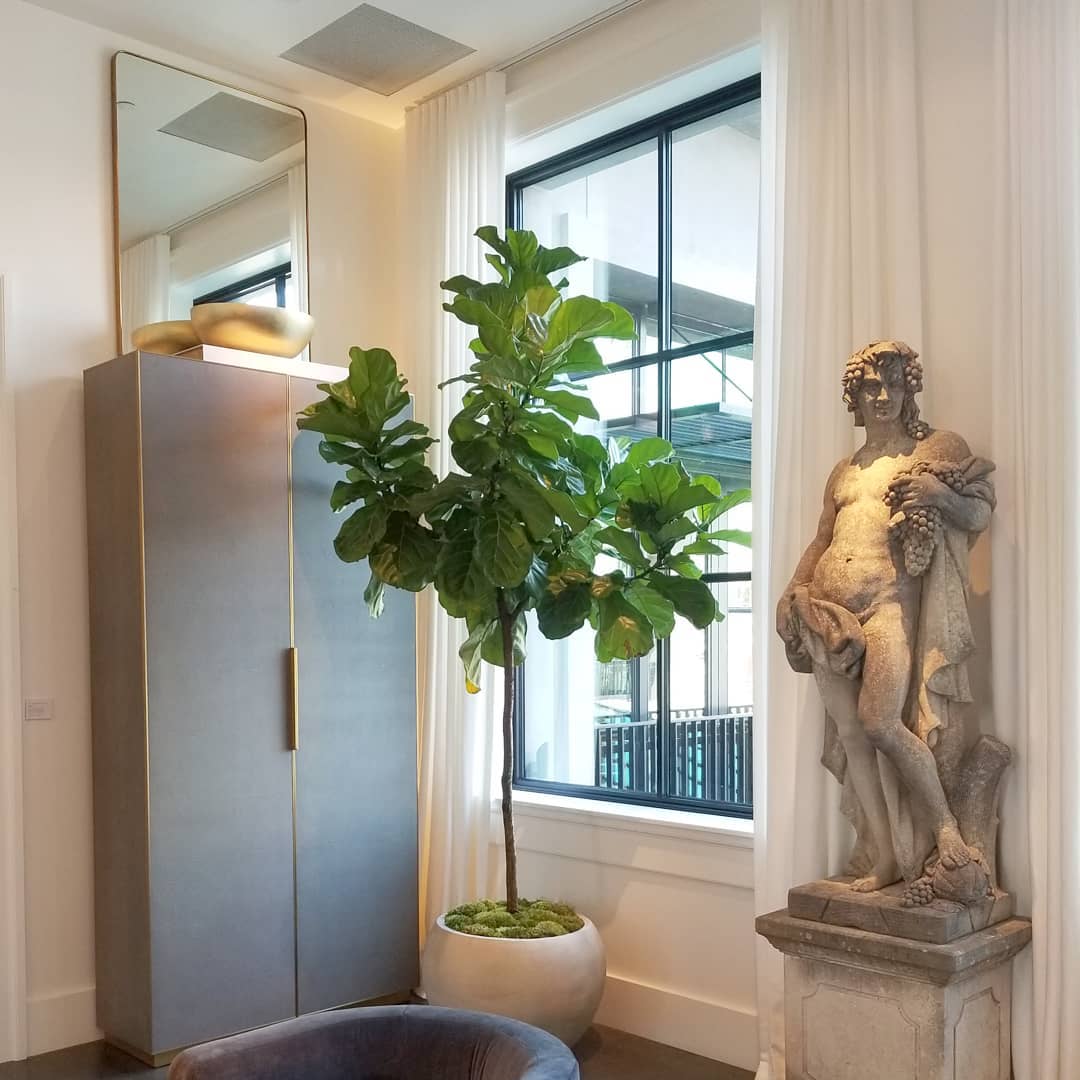 a room with a statue and a potted plant