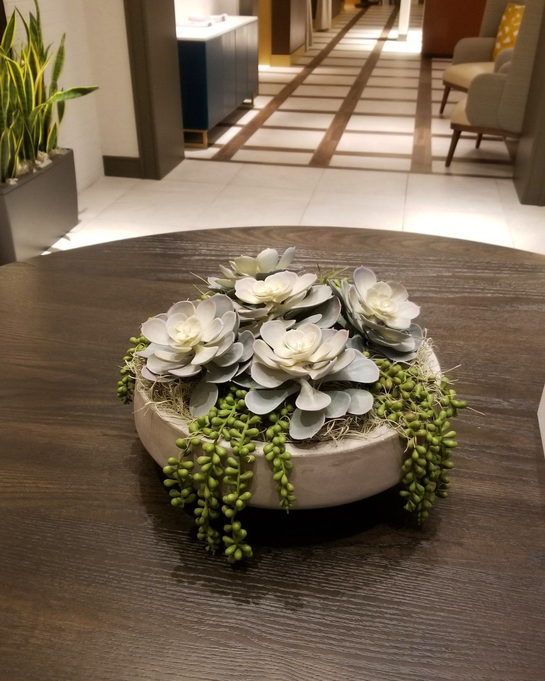 a bowl of flowers is sitting on a wooden table