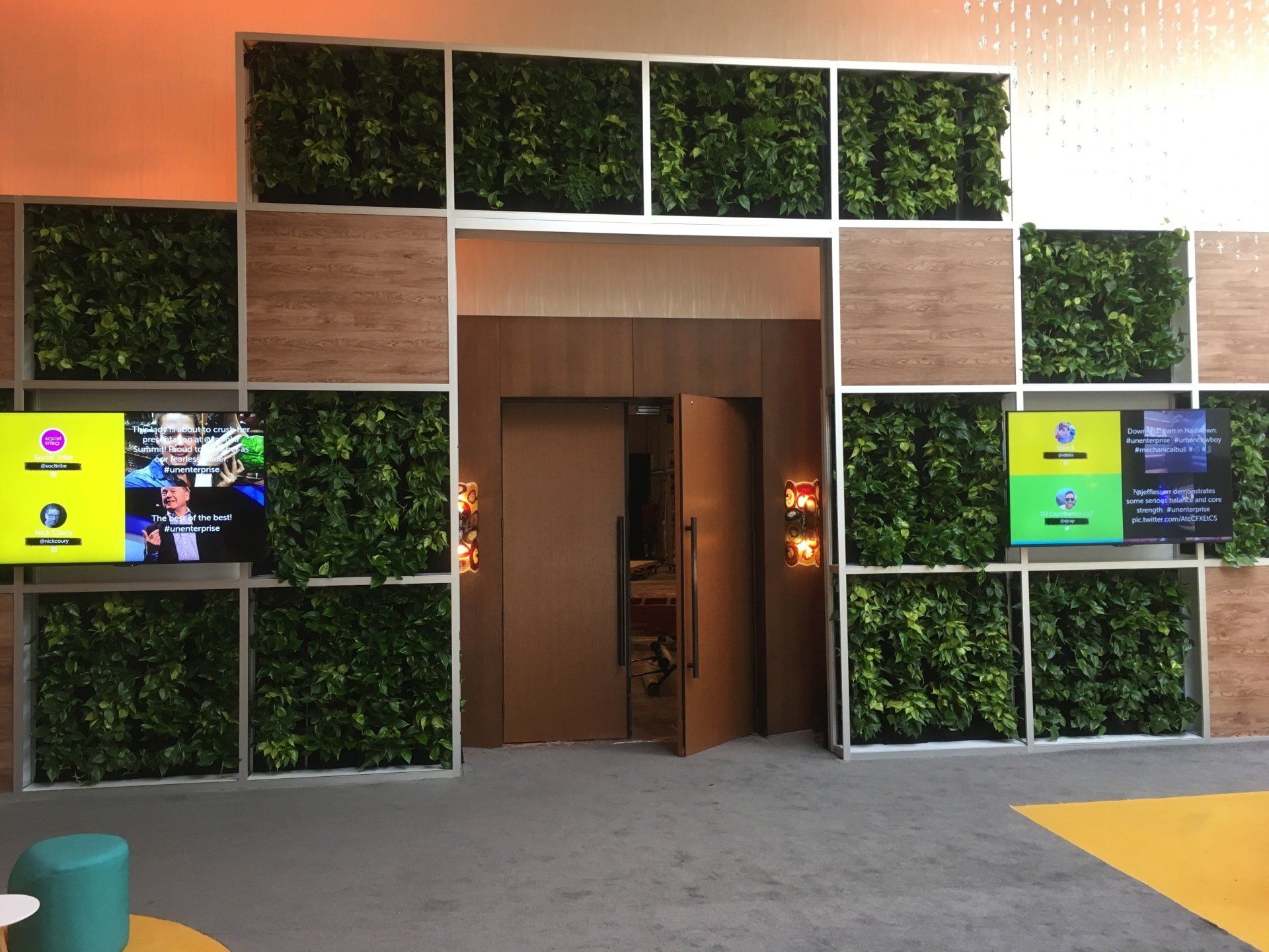 a room with a wall of plants and a door