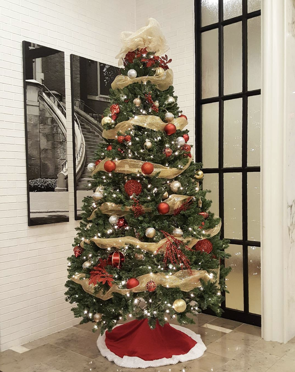 a christmas tree with red and gold decorations and a red skirt