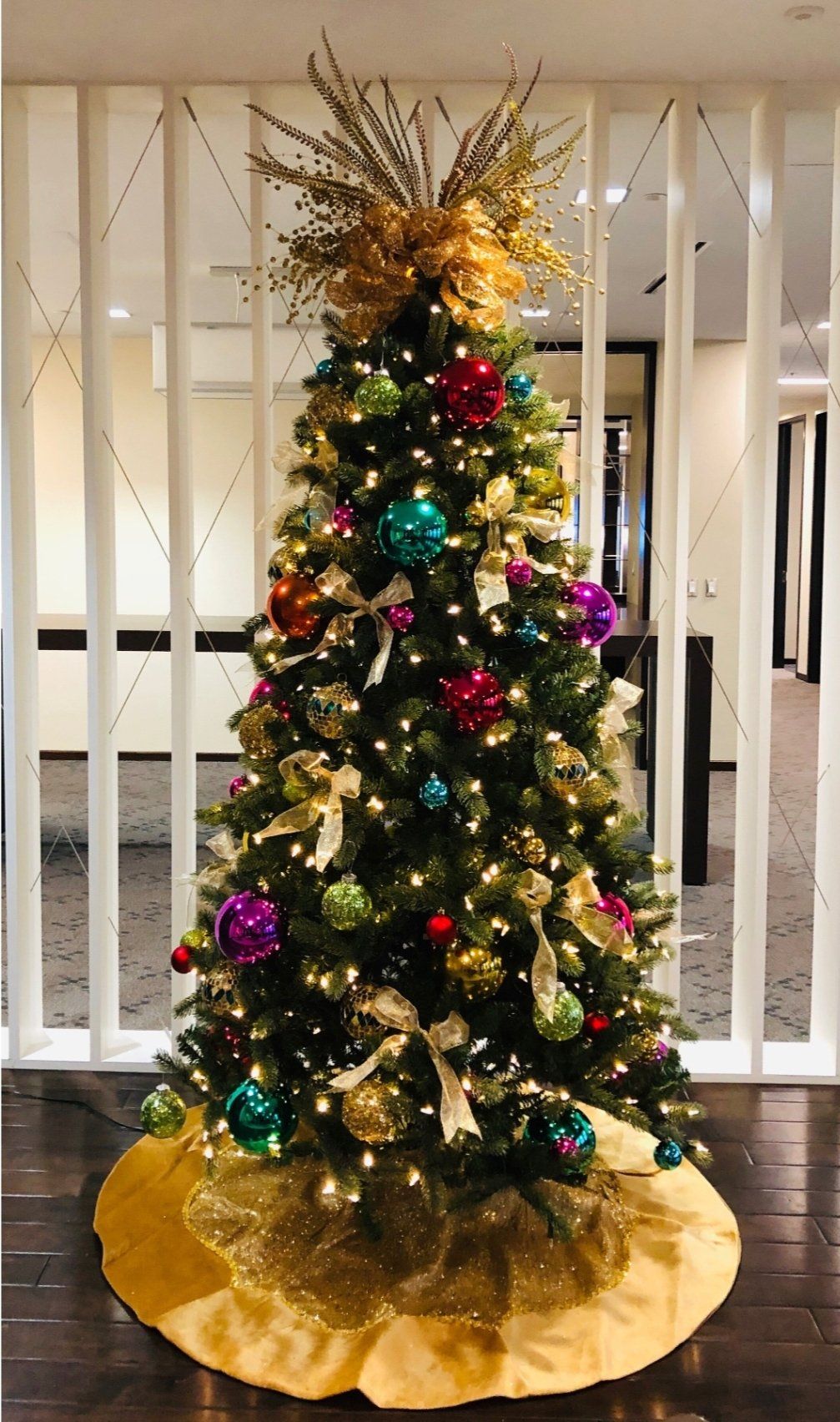a christmas tree with a yellow skirt is sitting in a room