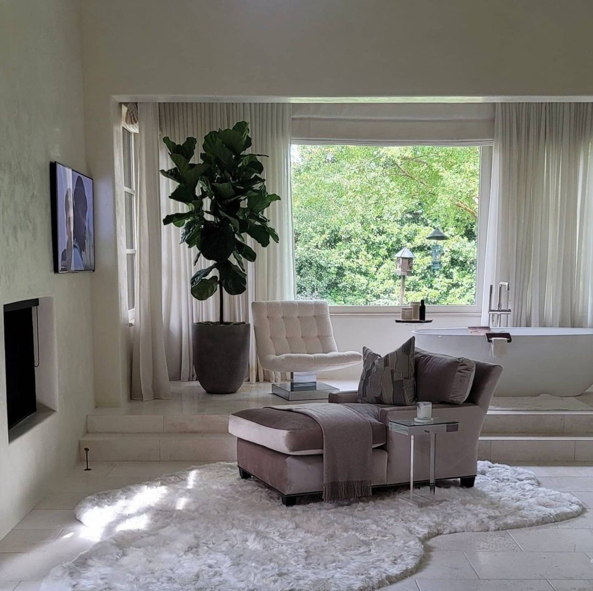 a living room with a chair and ottoman and a tub