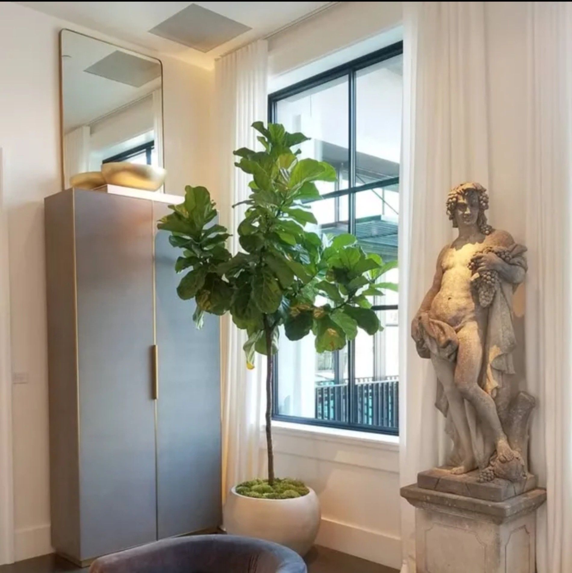 a statue of a man standing next to a potted plant