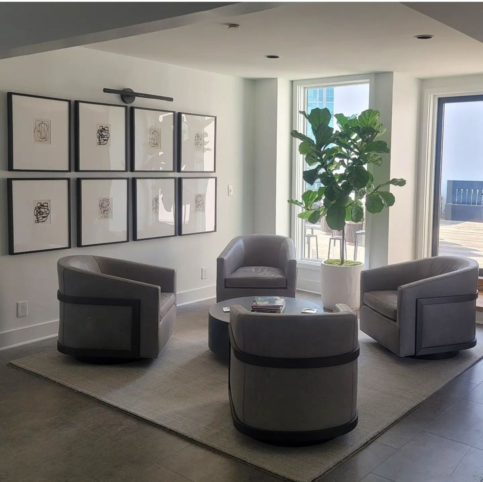 a living room with chairs a table and a plant