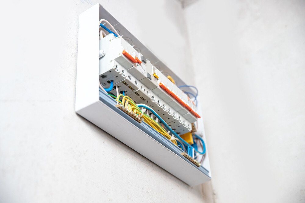 An Open White Electrical Consumer Unit Mounted on A White Wall — AC/DC Electrical, Air Conditioning & Refrigeration In Rockhampton, QLD