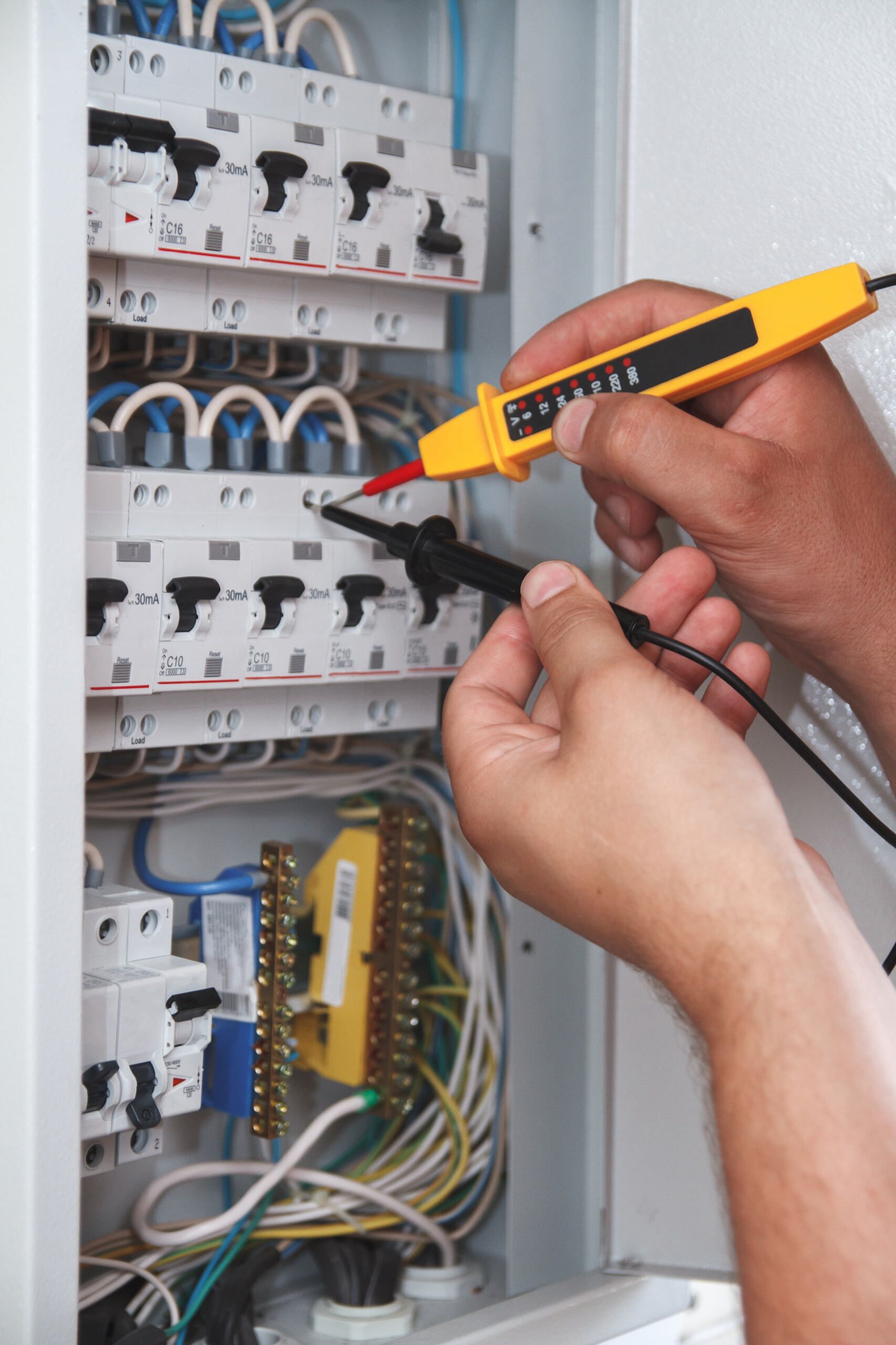 Hands Use a Voltage Tester to Check Circuit Breakers Inside an Electrical Panel — AC/DC Electrical, Air Conditioning & Refrigeration In Highfields, QLD