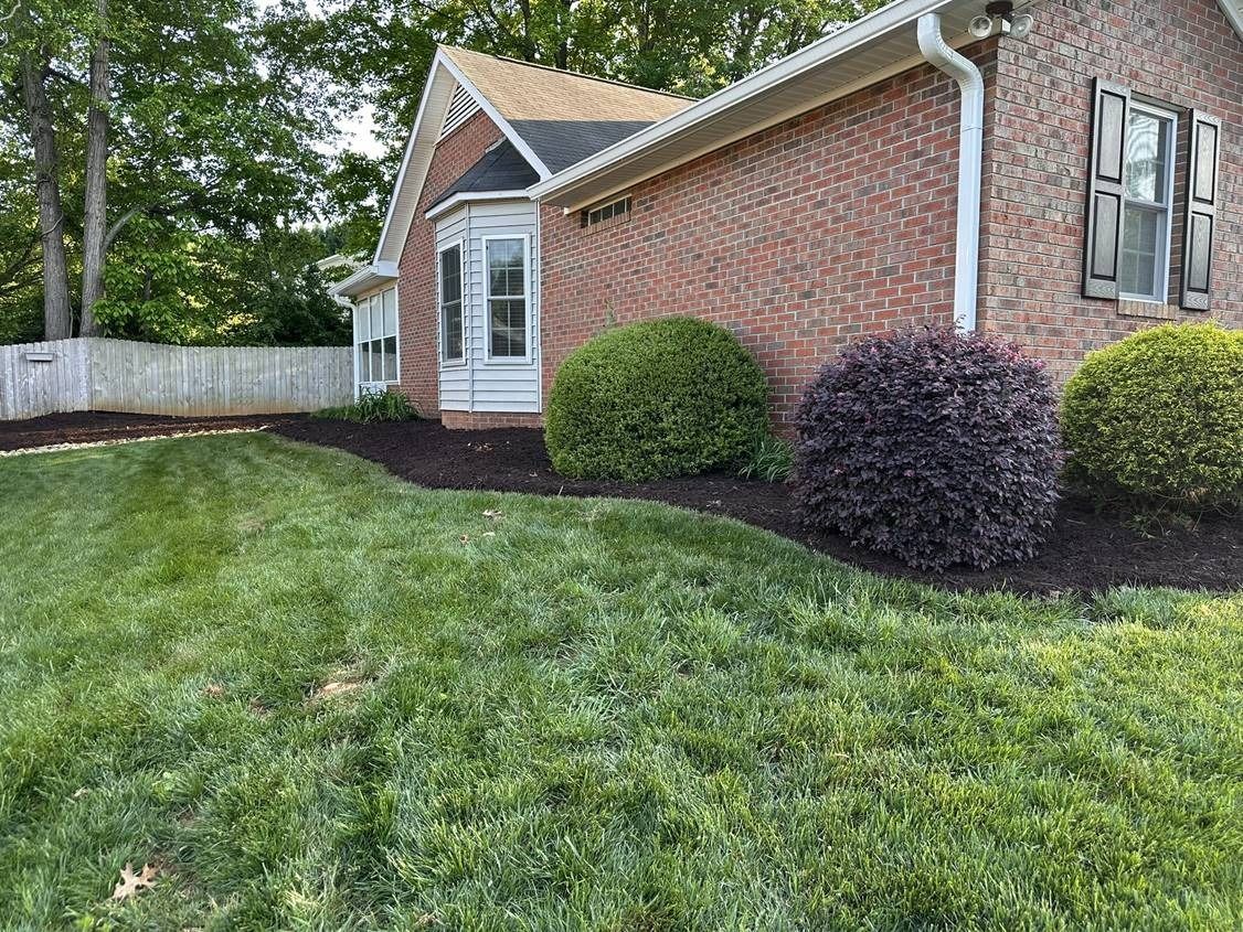 A brick house with a lush green lawn in front of it.