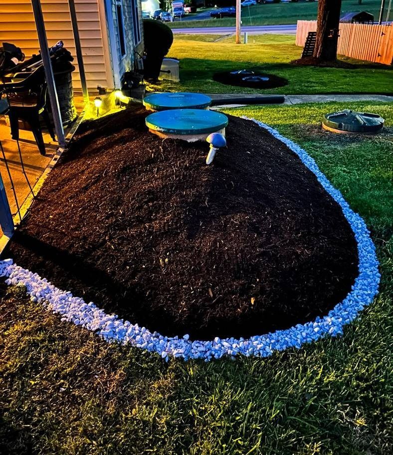 A pile of mulch is sitting in the middle of a lush green yard.