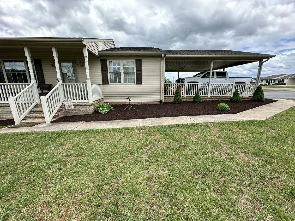 A mobile home with a porch and a truck parked in front of it.
