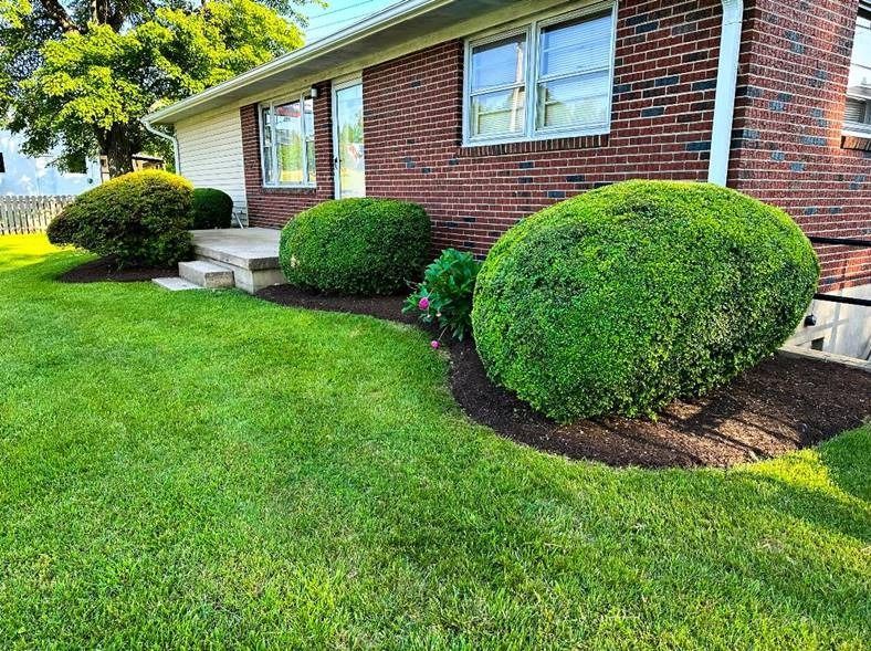 A brick house with a lush green lawn in front of it.