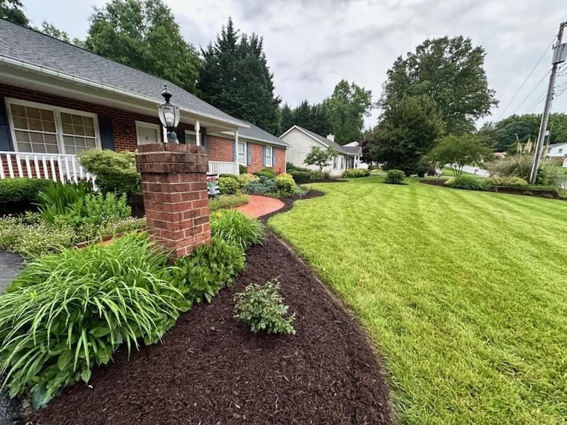 A house with a lush green lawn and a brick pillar in front of it.