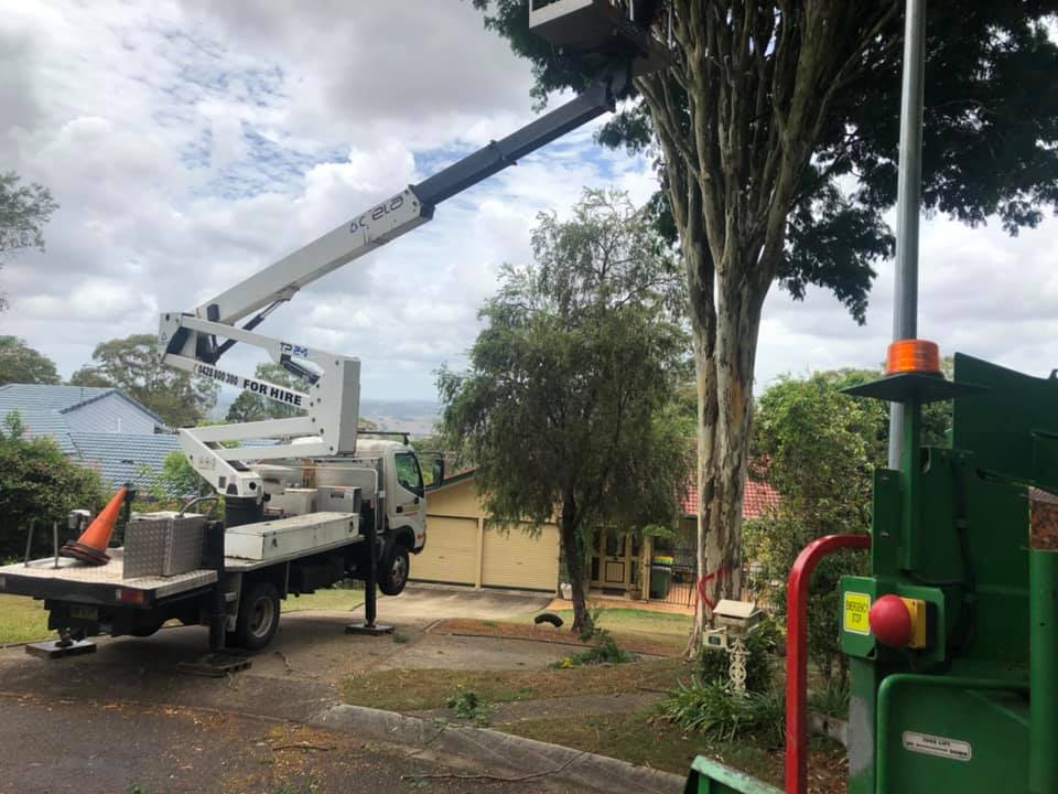 A Crane is Sitting on the Back of a Truck Next to a Tree Chipper — Steve Cubis Tree Services In Lismore, NSW