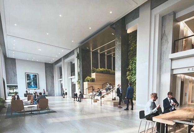 A group of people are sitting at tables in a large lobby of a building.