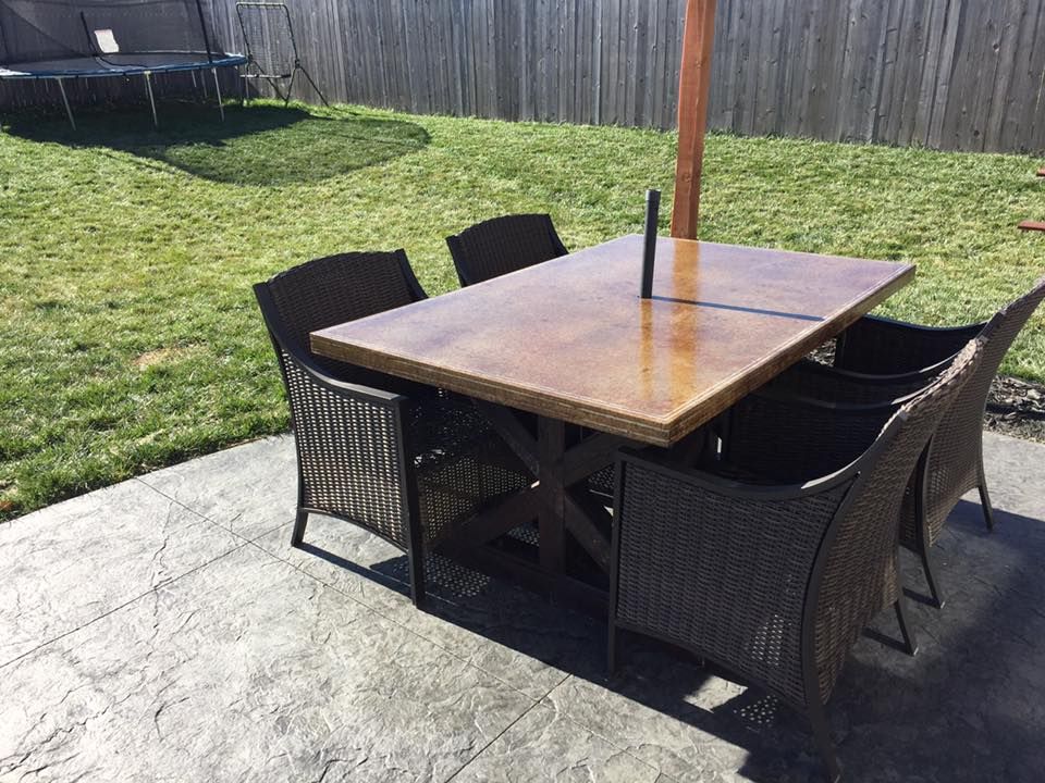 A table and chairs are sitting on a patio in a backyard.