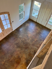 An aerial view of a living room with a stained concrete floor.