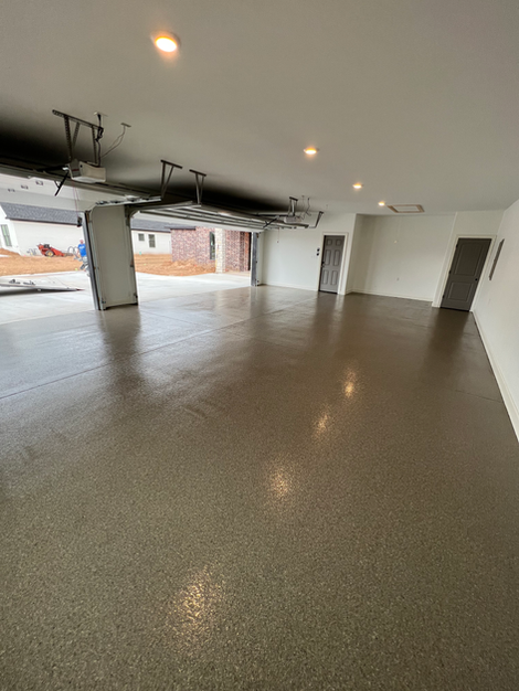A large empty garage with a concrete floor.