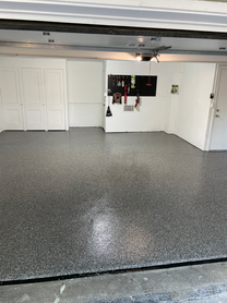 A garage with a gray floor and white walls.
