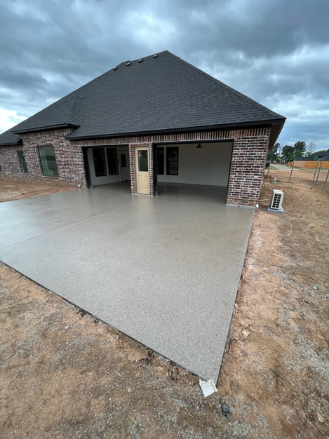 A brick house with a concrete driveway in front of it.