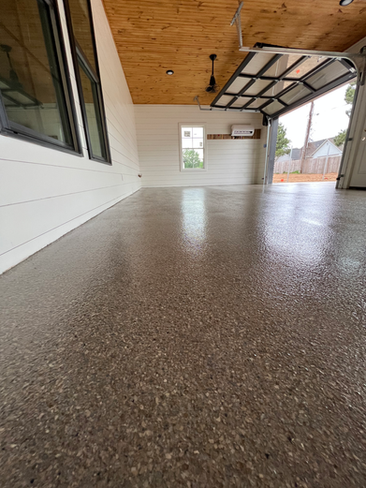 A garage with a concrete floor and a wooden ceiling.
