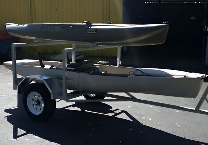 Two Kayaks Are On A Trailer In A Parking Lot — Hastings Trailer Centre in Port Kempsey, NSW
