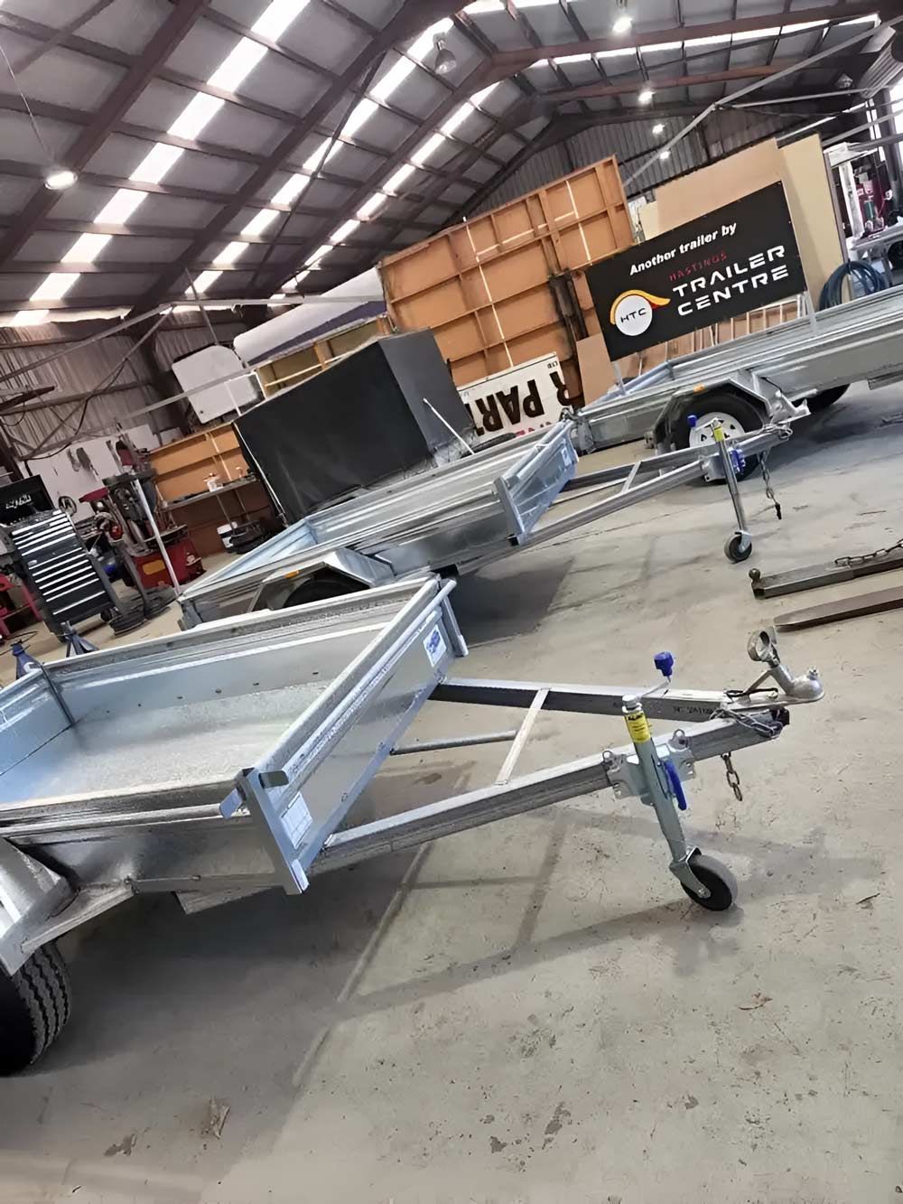A Trailer Is Sitting In A Warehouse Next To A Truck — Hastings Trailer Centre in Port Kempsey, NSW