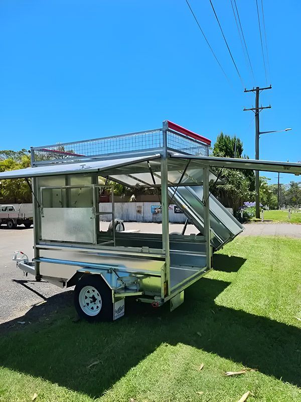 A Trailer Is Displayed On The Grass In A Parking Lot — Hastings Trailer Centre in Taree, NSW