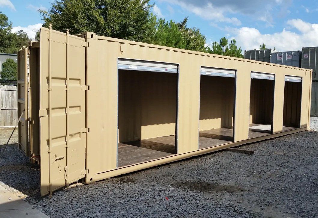 A large shipping container with the doors open is sitting in a gravel lot.