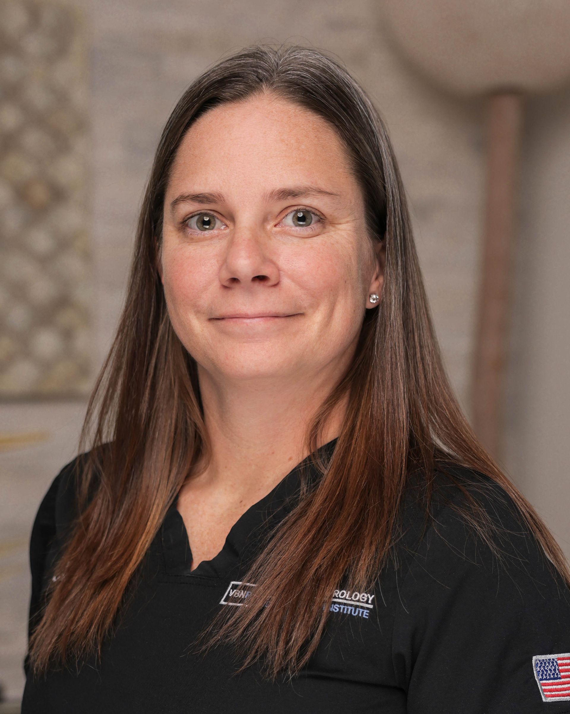 A woman with long hair is wearing a black shirt with an american flag on the sleeve.