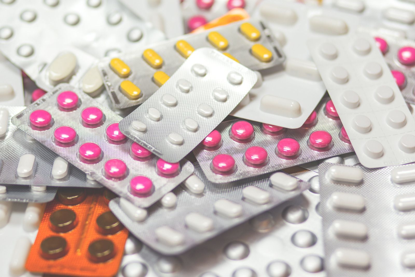 Pile of various colored pills in blister packs.