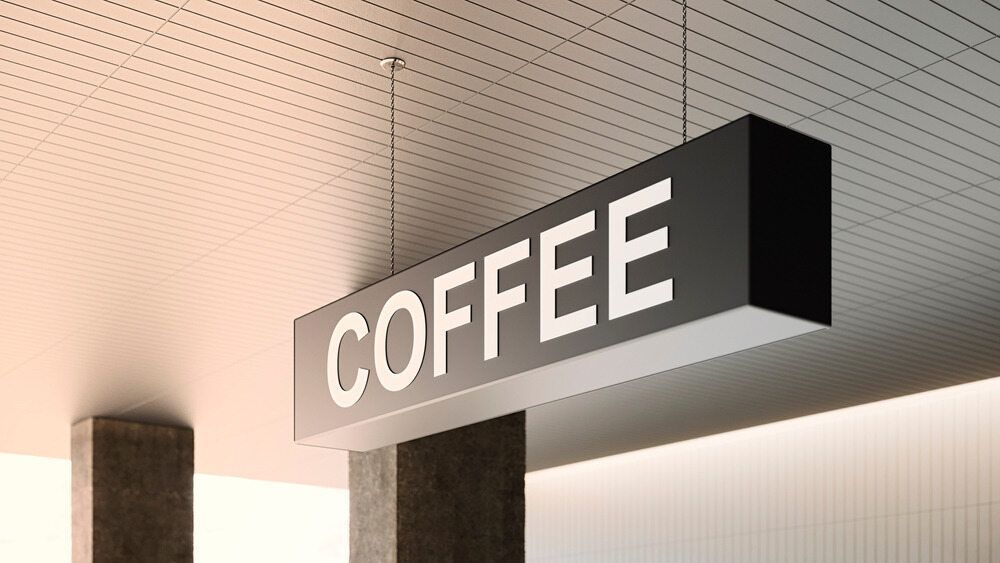 A Coffee Sign is Hanging From the Ceiling of a Building — Caledonian Colour In Kunda Park, QLD