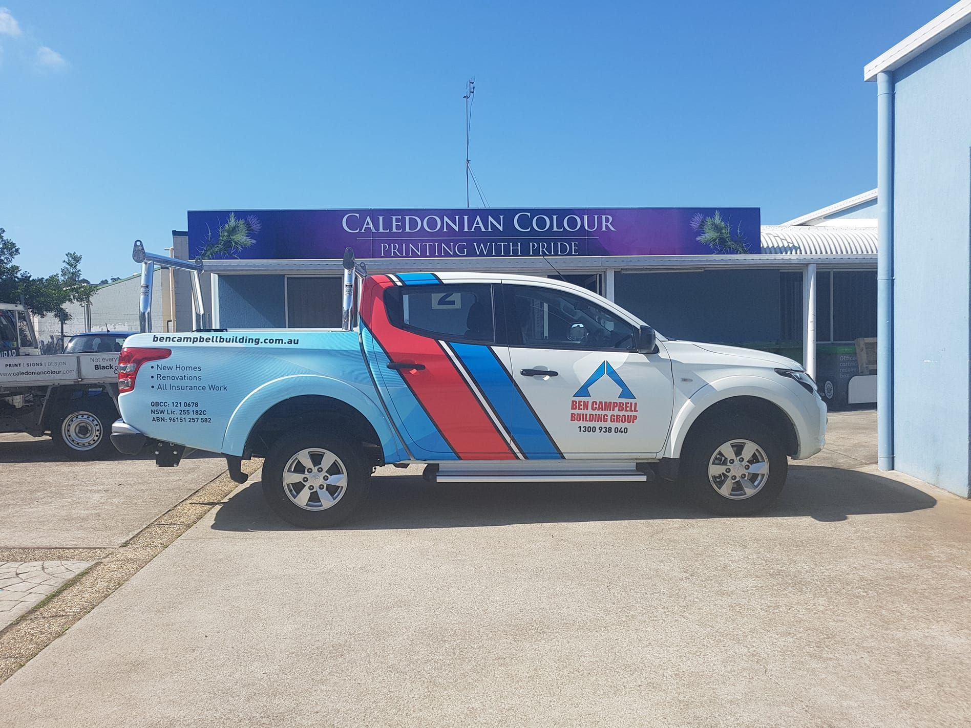 A Blue and White Truck is Parked in Front of a Building — Caledonian Colour In Caloundra, QLD