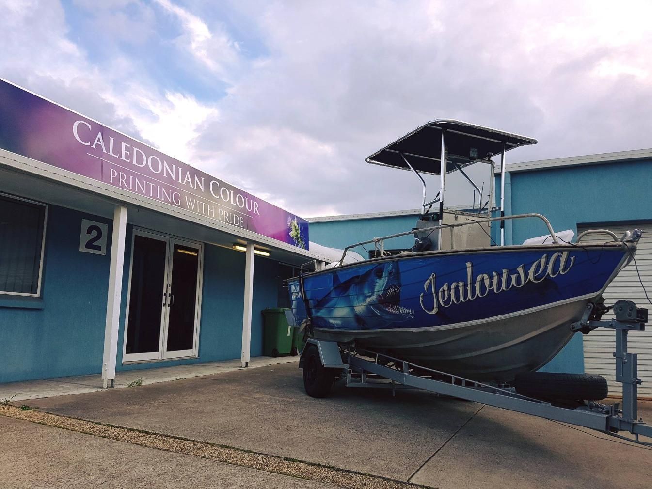 A Boat on a Trailer is Parked in Front of a Building — Caledonian Colour In Kunda Park, QLD