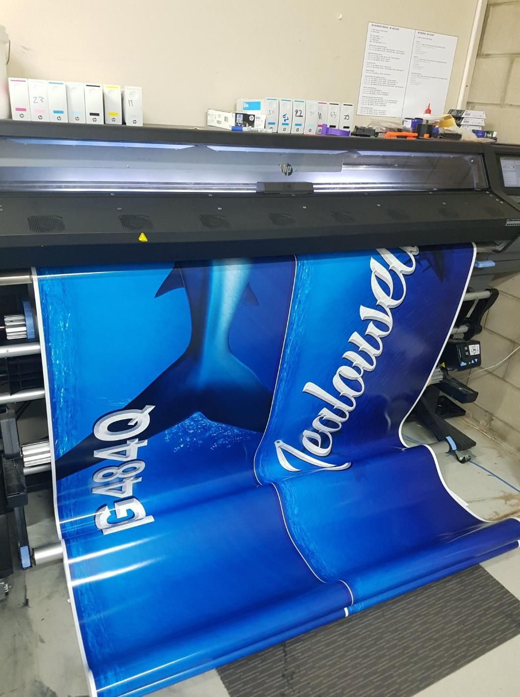 A Large Machine is Printing a Blue and White Poster — Caledonian Colour In Kunda Park, QLD