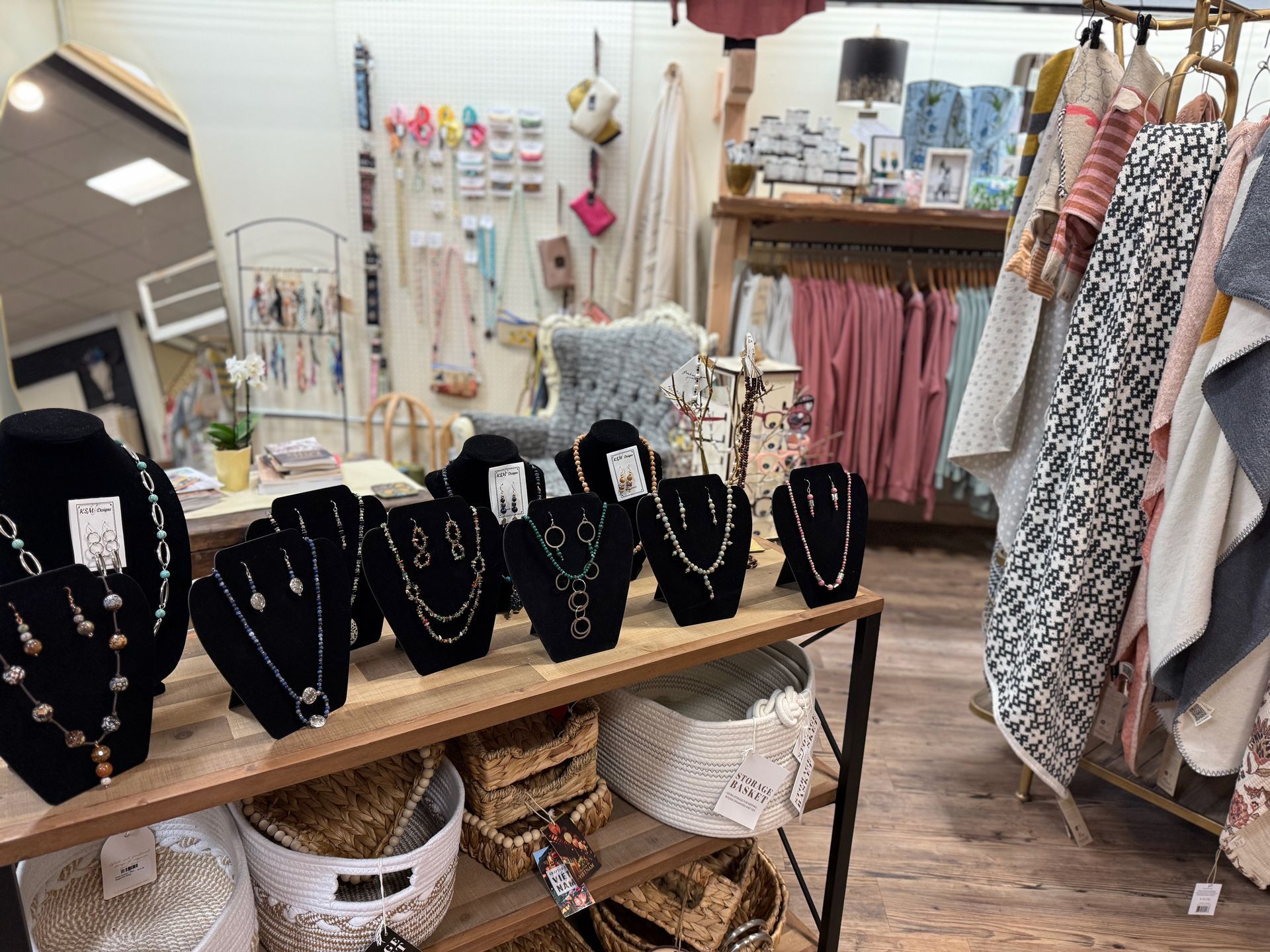 There are many necklaces on display on a table in a store.