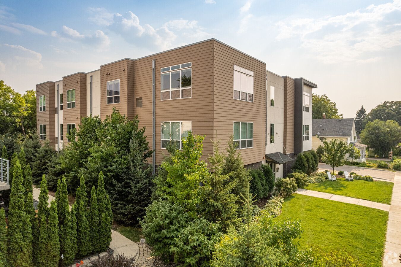 An aerial view of a large apartment building surrounded by trees and grass.