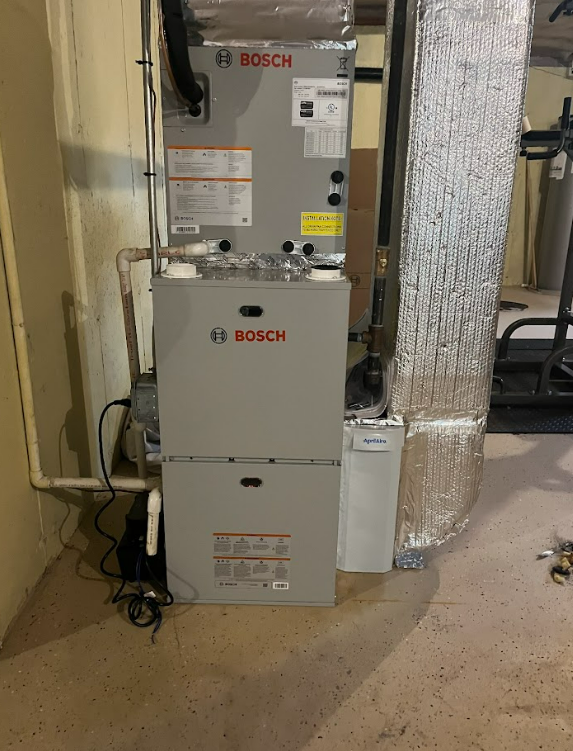 A bosch air conditioner is sitting in a basement.