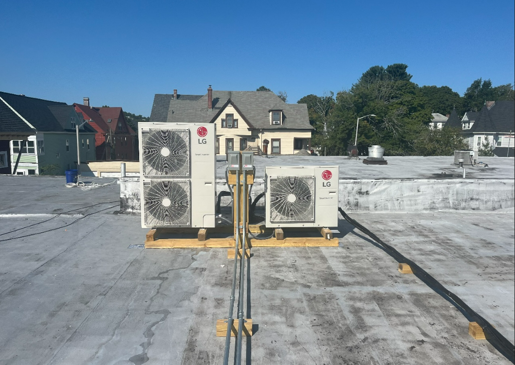 Two lg air conditioners are sitting on top of a roof.