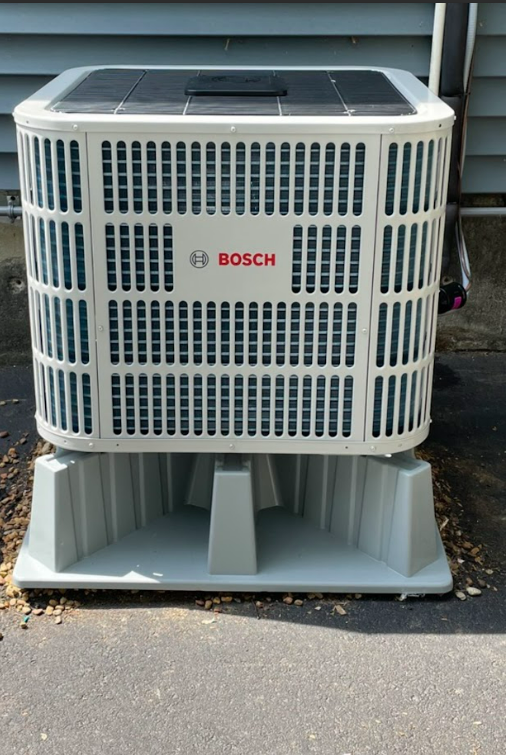 A bosch air conditioner sits on a concrete base