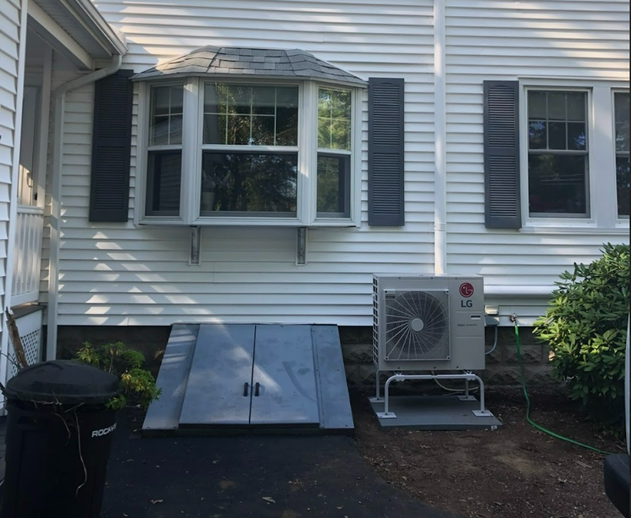 A white house with black shutters and an lg air conditioner