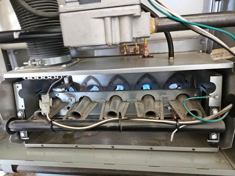 Furnace with lit blue flames from gas burners.