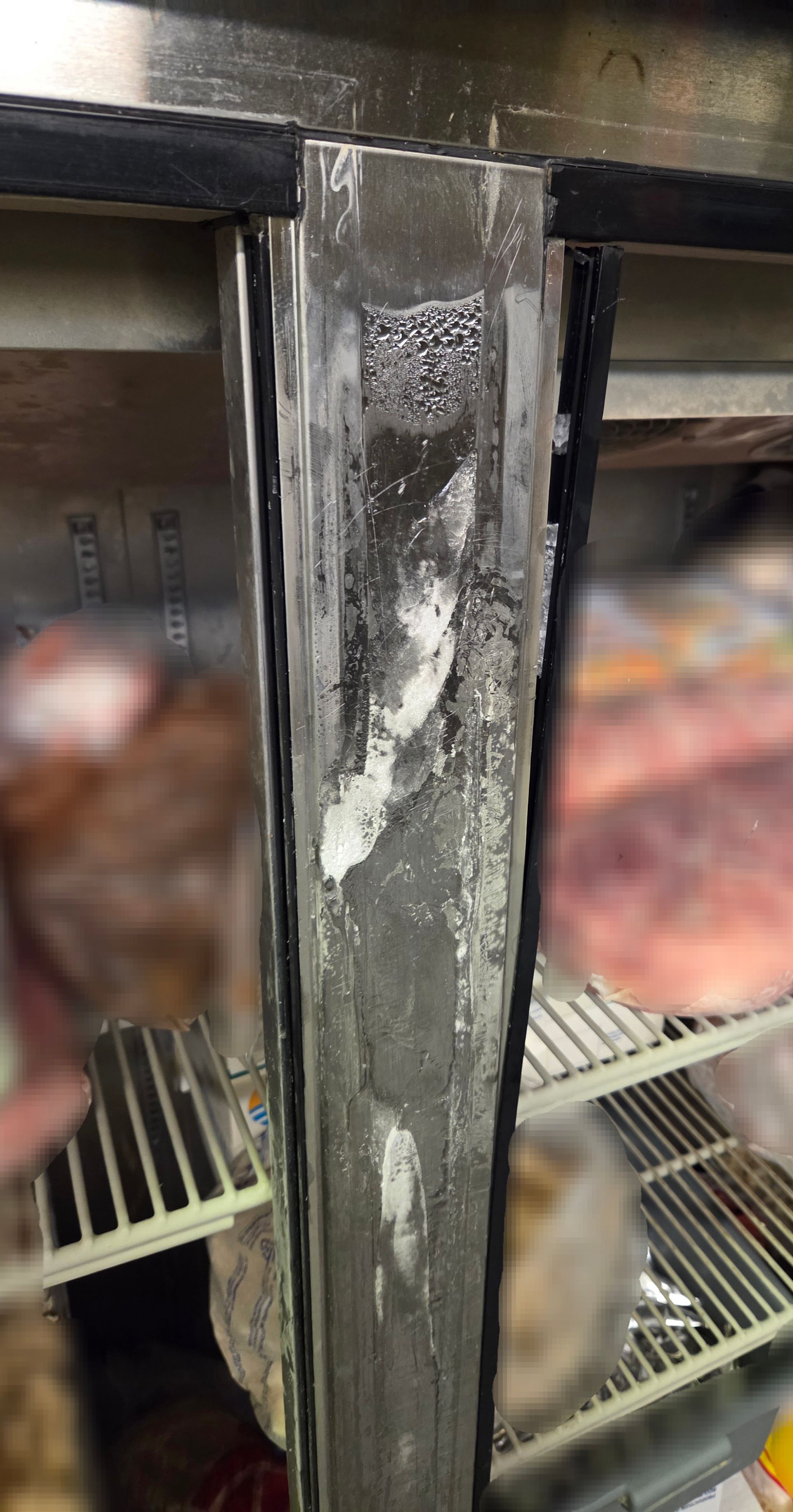 Refrigerator door frame with significant ice buildup.