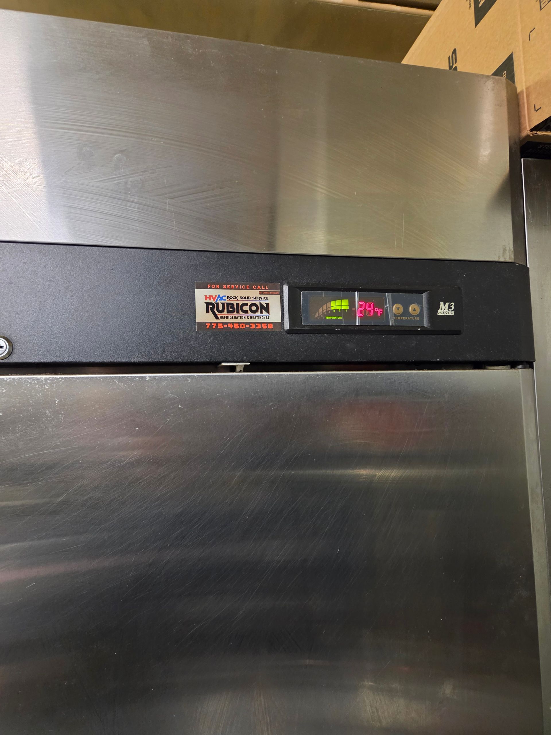 Stainless steel refrigerator with digital display showing a temperature. The brand name is Rubicon.
