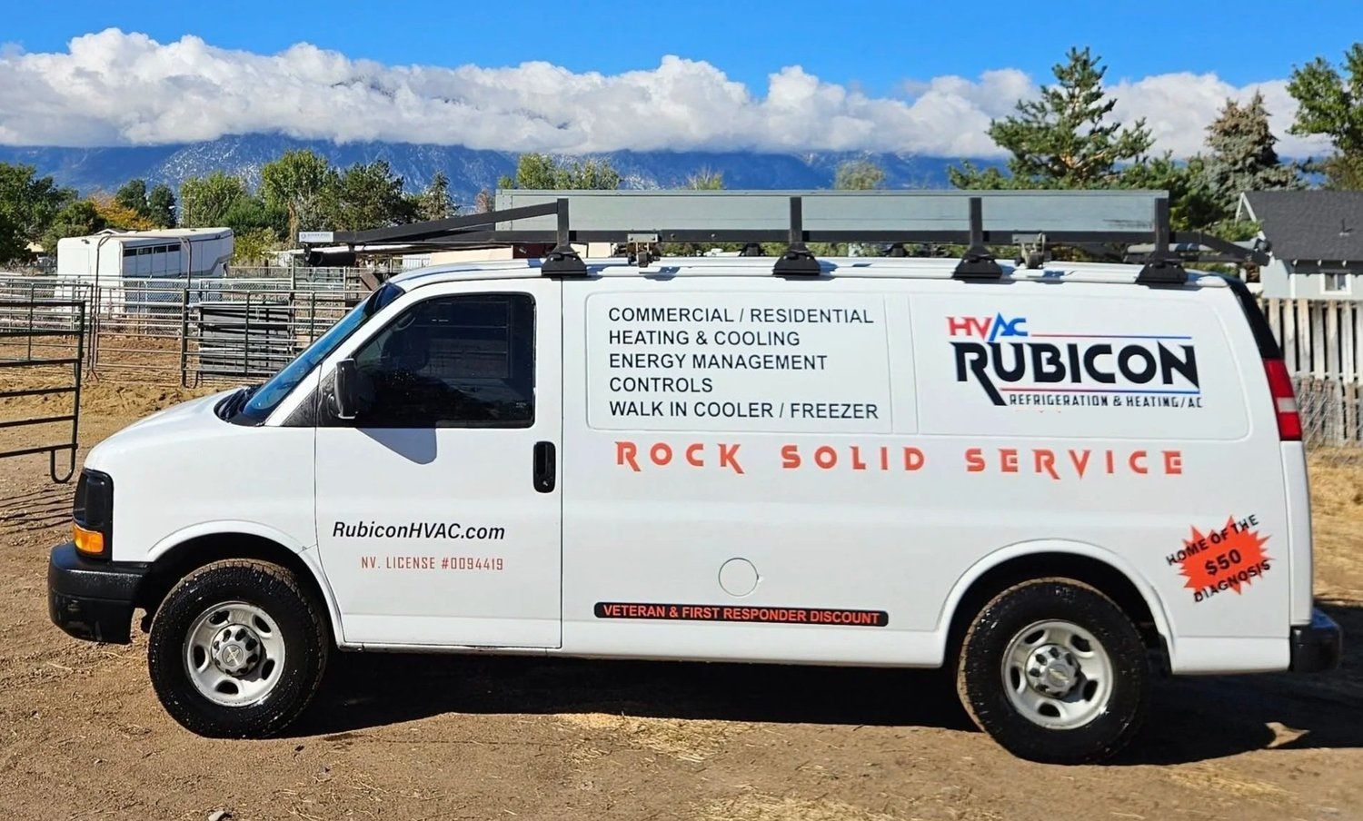 White HVAC service van with roof rack, logo, and phone number parked outdoors.
