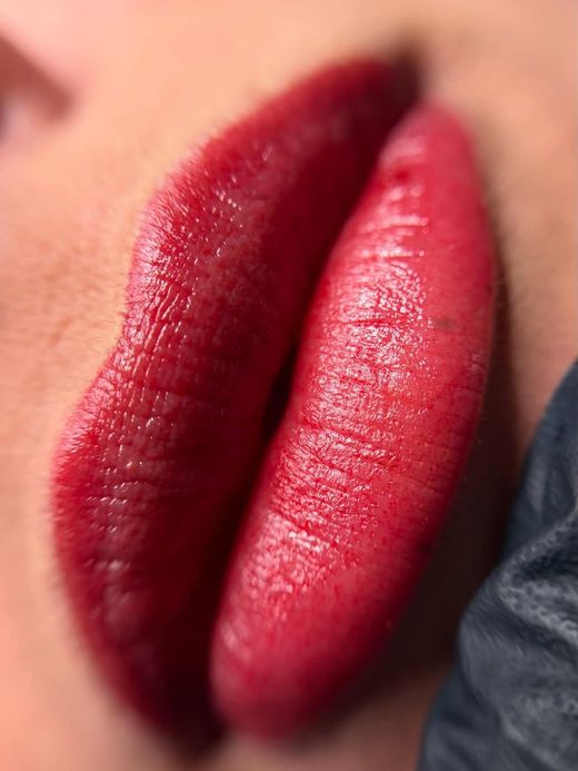 Primo piano di labbra rosse lucide con rossetto rosso scuro