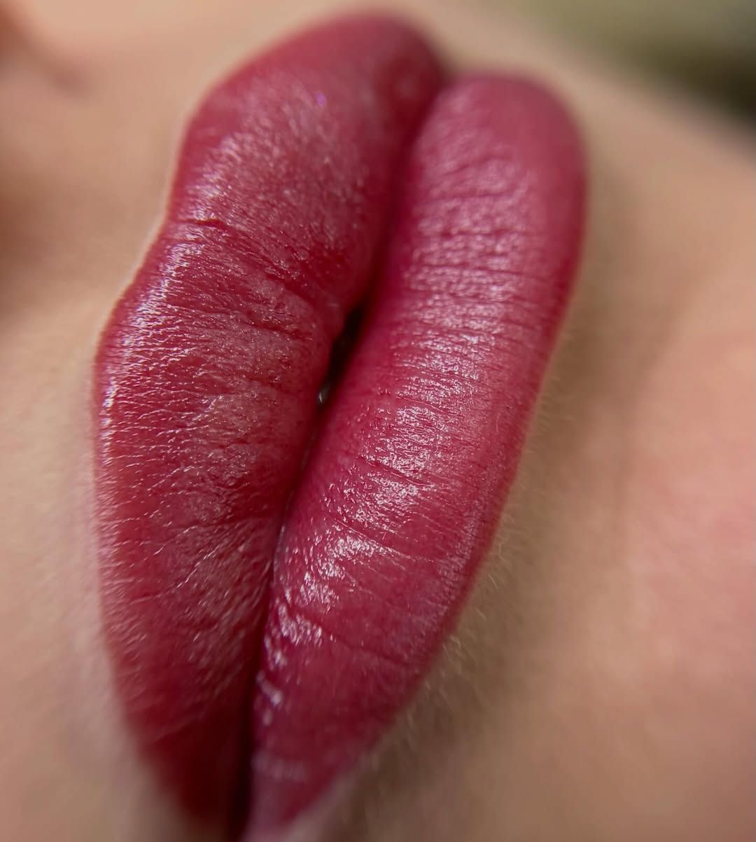 Primo piano di labbra rosse lucide con rossetto rosso scuro
