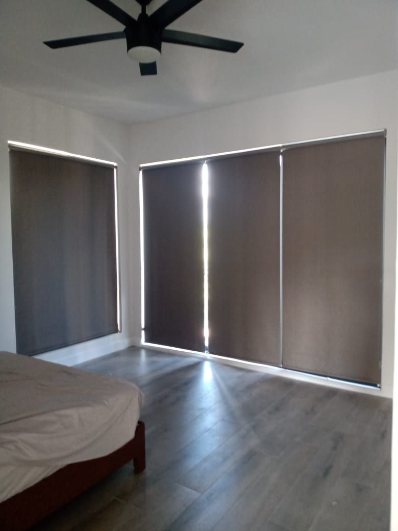 Un dormitorio con una cama y un ventilador de techo.